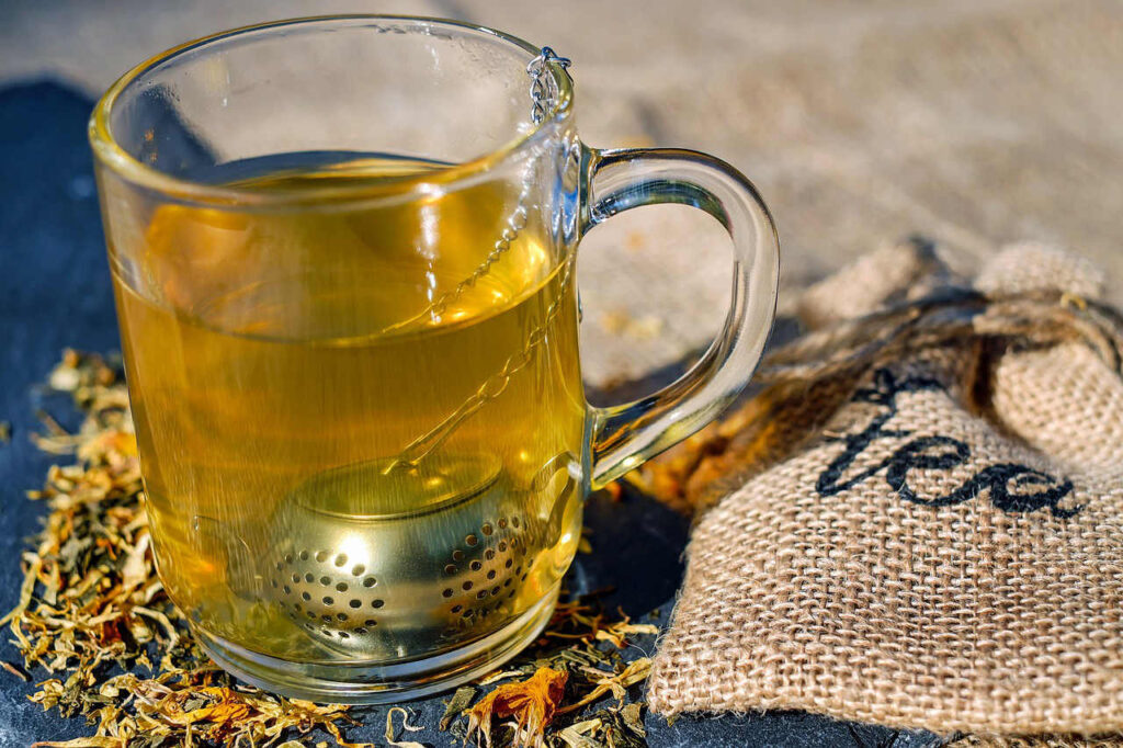 Tasse en verre avec du thé en train d'infuser