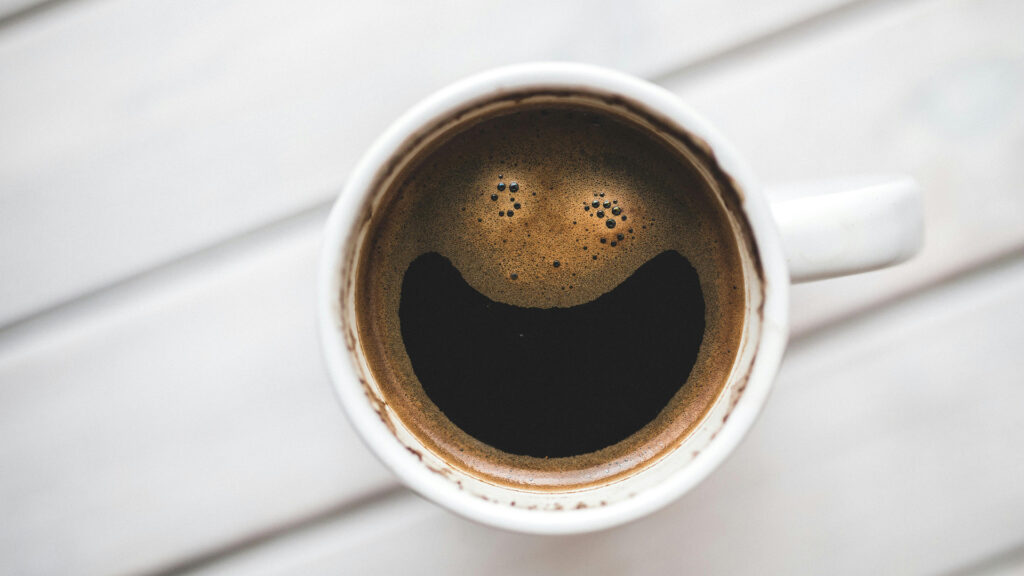 Tache de café avec un smiley souriant dans le café
